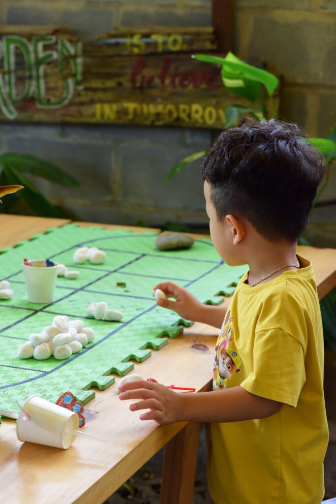 A young child focuses on a creative craft activity in an indoor setting, emphasizing fun learning.